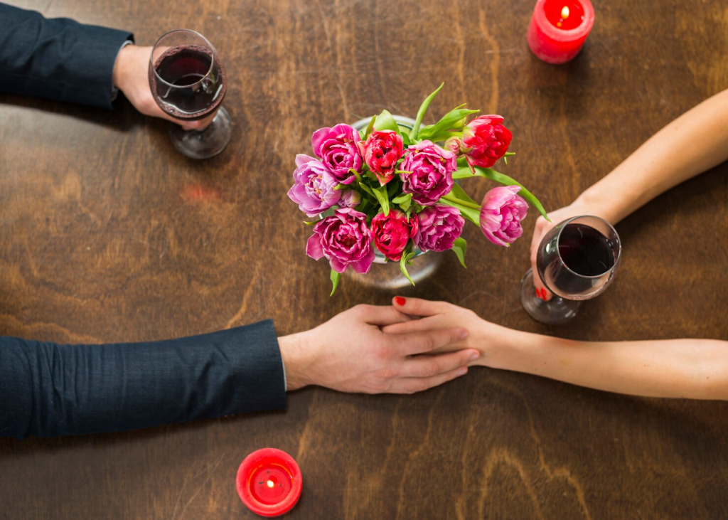 man-holding-hands-with-woman-table-with-glasses-flowers_23-2148024579.jpg